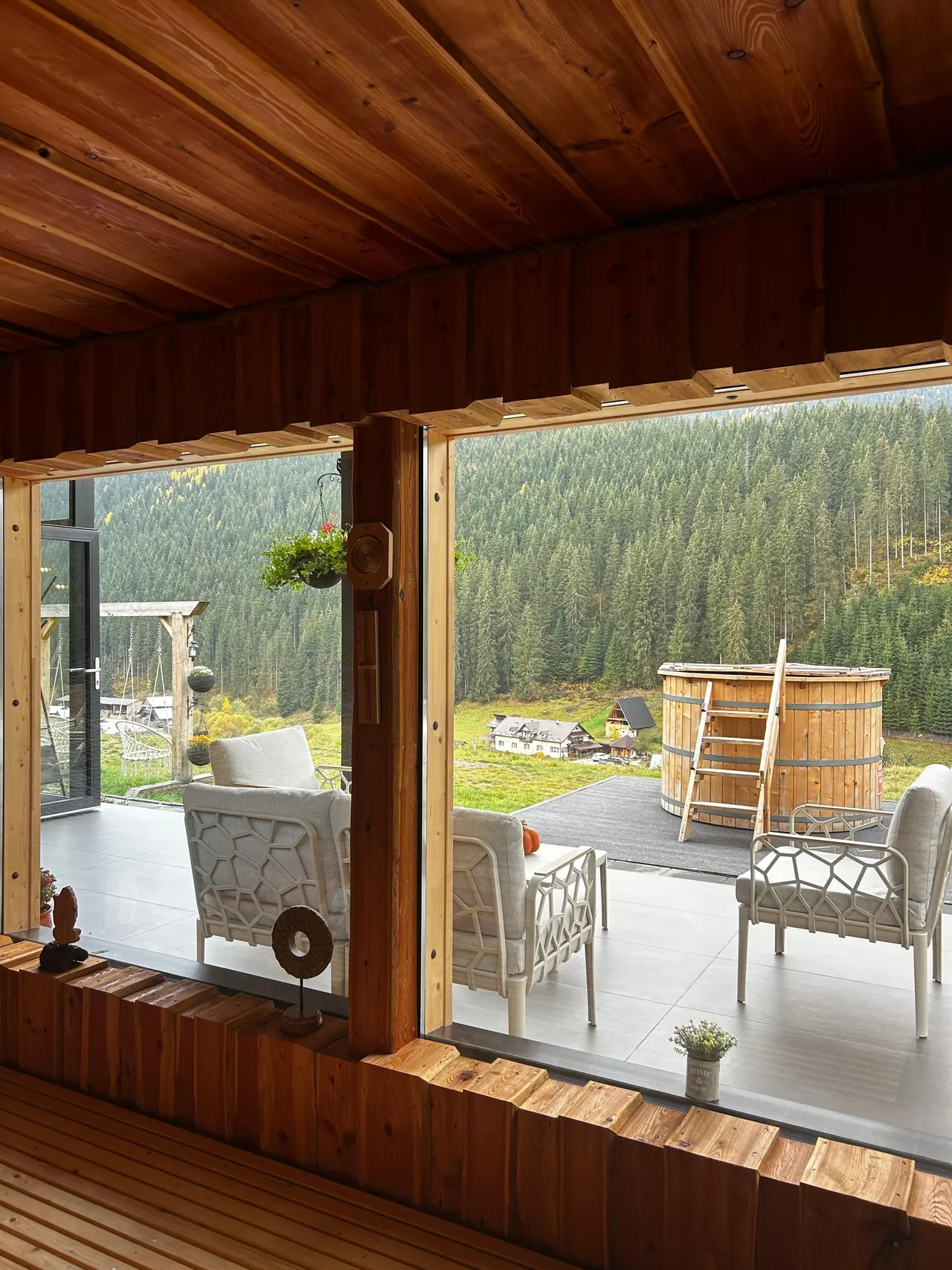 Blick durch einen Holzrahmen auf Jacuzzi und Tal