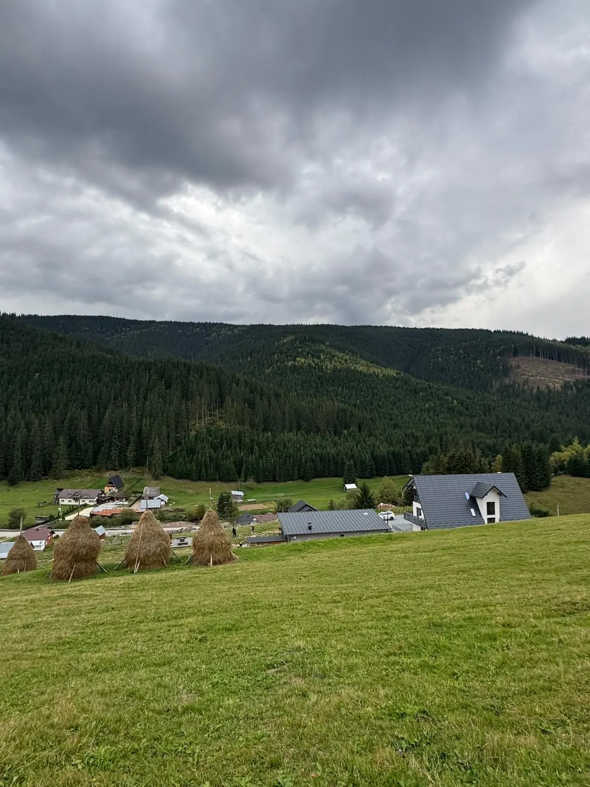 Das Chalet über einem Tal mit Heuhaufen