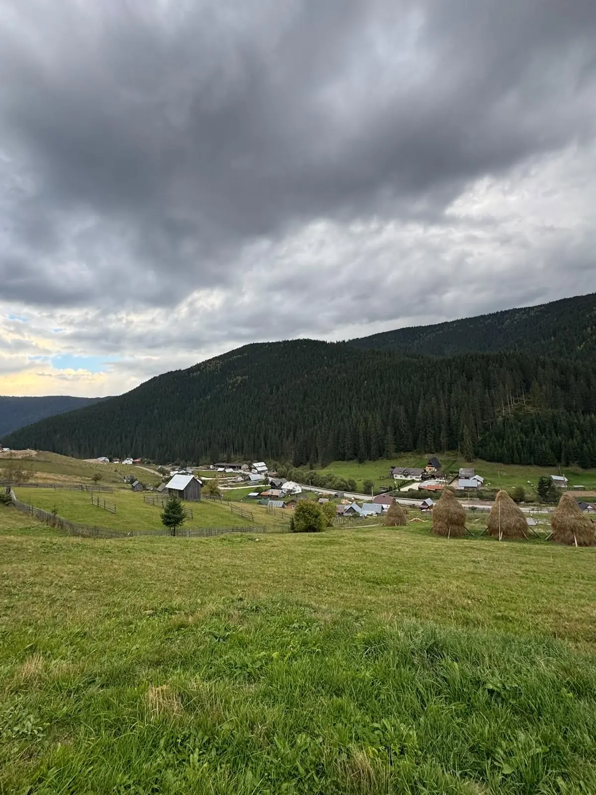 Das Tal von Gura Glodului mit Heuhaufen und Wolken